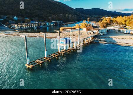 Vista aerea della spiaggia di Arkhipo-Osipovka e del vecchio molo in cemento, costa del mare nero, resort per vacanze e piacere, vista dall'alto. Foto Stock