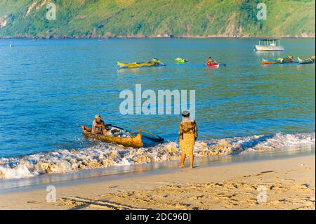 Uomo indonesiano di ritorno all'alba da un viaggio di pesca a Kuta Beach presso il tradizionale villaggio di pescatori di Kuta Lombok, Indonesia, Asia Foto Stock