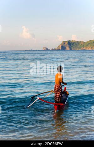 L'uomo indonesiano parte da un viaggio di pesca all'alba a Kuta Beach, Kuta Lombok, Indonesia, Asia, sfondo con spazio per la copia Foto Stock