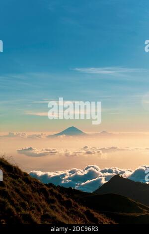 Paesaggio Foto del Tramonto dietro il Monte Agung e il Monte Batur a Bali dal Monte Rinjani, Lombok, Indonesia, Asia, sfondo con spazio di copia Foto Stock