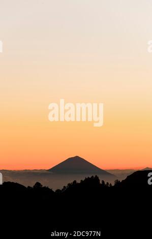 Monte Agung silhouette al tramonto dal Monte Rinjani, Lombok, Indonesia, Asia, sfondo con spazio di copia Foto Stock