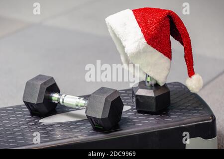 Cappello di Babbo Natale in palestra. Concetto di sport su Natale e Capodanno. Concetto di fitness, stile di vita sano e attivo. Foto Stock