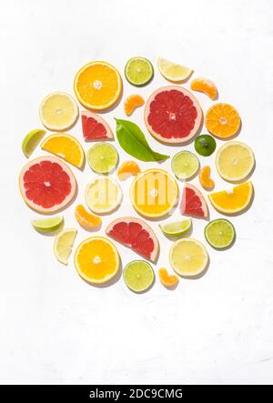 Motivo colorato fatto di fette di agrumi arancio, limone, lime e pompelmo. Gin guarnitura su sfondo bianco Foto Stock