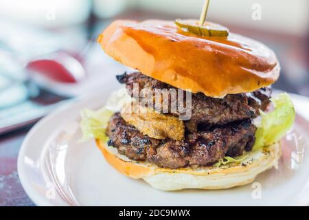 Sandwich con hamburger doppio in una cena locale a Cagayan de Oro City, Filippine Foto Stock