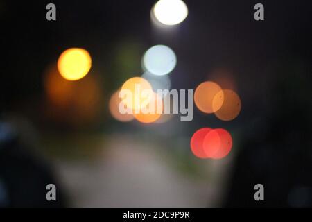 Un bokeh colorato si illumina su uno sfondo scuro - perfetto per sfondi Foto Stock