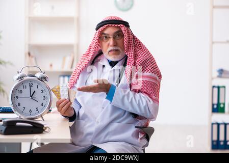 Medico arabo maschile esperto nel concetto di gestione del tempo Foto Stock