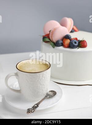 caffè e torta del mattino con macaron e bacche. buon concetto del mattino. contenuto del blogger dimensioni verticali. fuoco selettivo Foto Stock