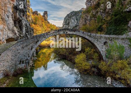 Il vecchio ponte in pietra ad arco di Kokori (Noutsos) durante la stagione autunnale situato sul fiume di Voidomatis a Zagori, Epiro Grecia. Foto Stock