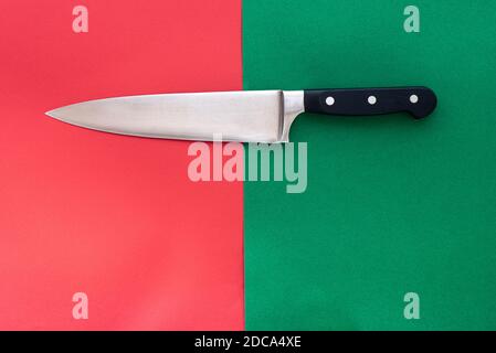 Grande coltello da carving su sfondo rosso e verde diviso. Foto Stock