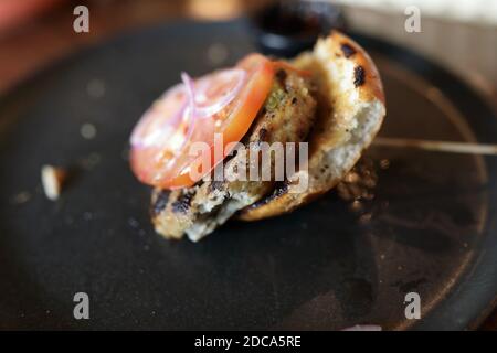 Avanzi di hamburger sul piatto nel ristorante Foto Stock