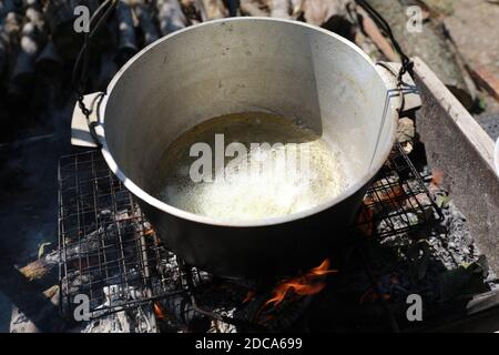 Friggere cipolle in calderone sul fuoco per pilaf Foto Stock