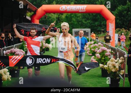 KHARKIV, UCRAINA - 2 AGOSTO 2020: Kharkiv triathlon Via di ferro. Il corridore dopo la transizione al ciclismo. Triatleta che corre in tuta triathlon tr Foto Stock