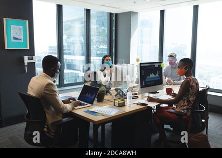 Diversi colleghi indossano maschere in ufficio Foto Stock