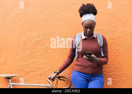 Ritratto di donna afroamericana che usa lo smartphone per strada Foto Stock