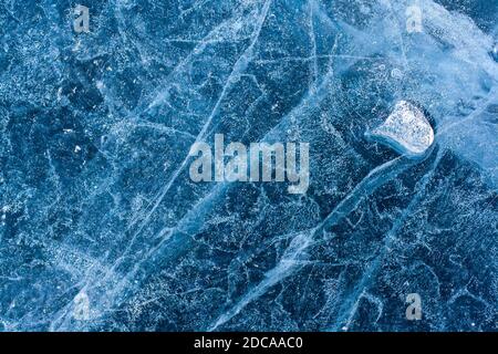 Incredibile struttura di ghiaccio con crepe e bolle d'aria. Poco ghiaccio fuso galleggiare su ghiaccio blu. Modello invernale. Orizzontale. Foto Stock