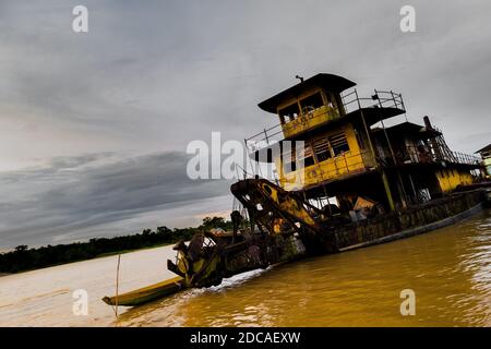 Un vecchio sogno d'oro abbandonato è visto ancorato dalla riva del fiume Atrato a Quibdó, la regione della foresta pluviale del Pacifico della Colombia. Foto Stock