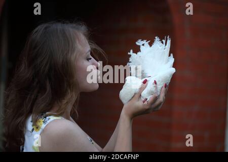 Felice ragazza con una colomba bianca nelle sue mani Foto Stock