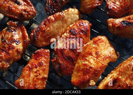 Primo piano ali di pollo bufalo cucinate su barbecue fumo griglia, vista ad angolo alto Foto Stock