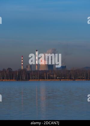 Immagine combinata della centrale di energia e calore con torri di raffreddamento sul lago in posizione verticale. Foto Stock