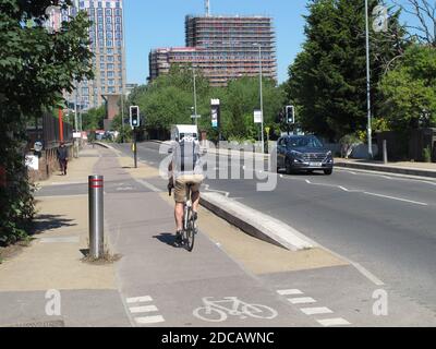 Londra, Regno Unito. Un ciclista utilizza la nuova pista ciclabile segregata lungo la trafficata Forest Road, parte dello schema Mini-Holland di Waltham Forest per strade più sicure. Foto Stock