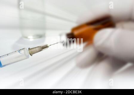 Vaccino e iniezione. Scienziato in laboratorio contenente una siringa con vaccini liquidi per bambini o adulti più anziani per covid-19 Foto Stock