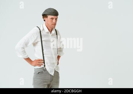 Ritratto di uomo hipster vestito con camicia bianca e jeans grigi e cappuccio di lana isolato su sfondo bianco. Spazio di copia sul lato destro Foto Stock