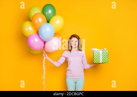 Ritratto di donna allegra tenere elio baloon verde punteggiato dono box lei si prepara per l'anniversario di amici indossare pullover casual stile isolato sopra Foto Stock
