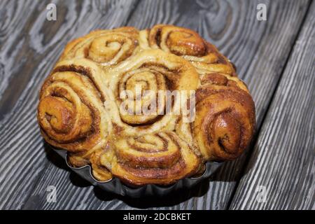 Cinnabon cotti al forno in forma. Stand su schede composite nere. Primo piano. Foto Stock