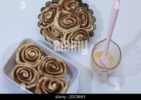 Cottura di cinnabon. L'impasto alla cannella si trova nel piatto da forno. Foto Stock