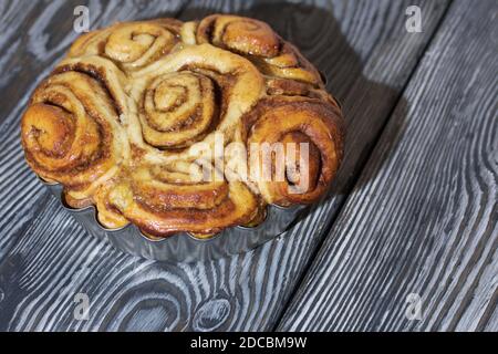 Cinnabon cotti al forno in forma. Stand su schede composite nere. Primo piano. Foto Stock