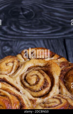 Cinnabon cotti al forno in forma. Stand su schede composite nere. Primo piano. Foto Stock