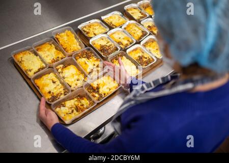 Cradley Heath, West Midlands, Regno Unito. 20 Nov 2020. Mentre la crisi di Covid continua a colpire le persone più vulnerabili della società, le banche alimentari continuano a fornire cibo di grande necessità alle famiglie più povere. Jeanette Happ, un volontario presso la Santa Trinity Church foodbank a Cradley Heath, West Midlands, cucina una partita di torte cottage pronti per il congelamento. Si preparano circa 30 alla settimana per dare fuori alle famiglie locali che non sono in grado di preparare o cucinare i propri pasti. Credit: Peter Lopeman/Alamy Live News Foto Stock