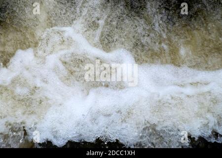 Schiuma turbolenta acqua frizzante che scorre in un ruscello in autunno Novembre Rural Carmarthensshire Galles Gran Bretagna Regno Unito KATHY DEWITT Foto Stock