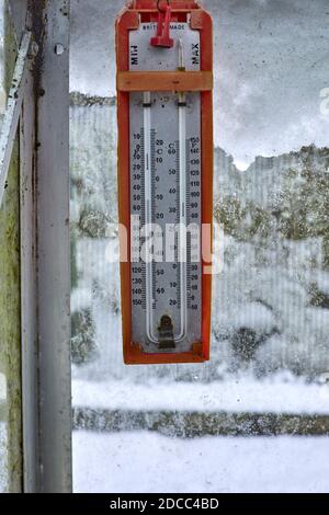 Inverno e un termometro Max e min appeso all'interno di un serra non riscaldata nel piccolo giardino a 900ft Foto Stock
