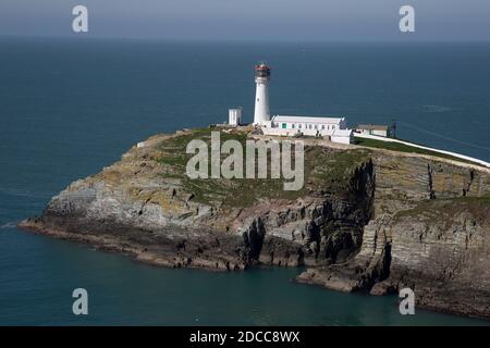 Una vista del faro di South Stack costruito sulla cima di una piccola isola al largo della costa nord-occidentale di Holy Island, Anglesey, Galles del Nord. Foto Stock