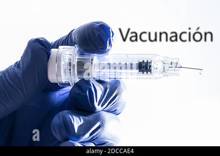 Bamberg, Germania. 12 Nov 2020. Bamberg, Germania 12 novembre 2020: Simboli - Coronavirus - 11/17/2020 UNA mano con guanti di gomma tiene una siringa di vaccinazione in mano, sullo sfondo è Vacunacion, immagine montaggio, illustrazione, feature/symbol/symbol foto/caratteristiche/dettaglio/| utilizzo nel mondo Credit: dpa/Alamy Live News Foto Stock