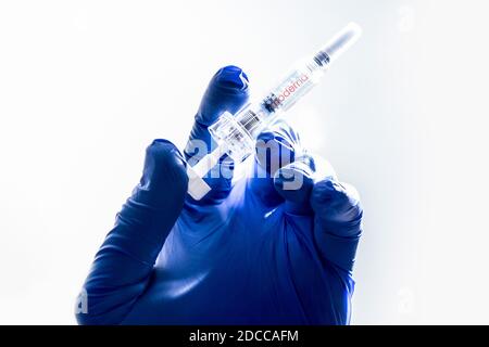 Bamberg, Deutschland. 12th Nov, 2020. Bamberg, Germany November 12, 2020: Symbols - Coronavirus - 11/17/2020 A hand with rubber gloves holds a vaccination syringe in one hand, the moderna logo can be seen on the syringe, image assembly, illustration, feature/symbol/symbol photo/characteristic/detail/| usage worldwide Credit: dpa/Alamy Live News Stock Photo