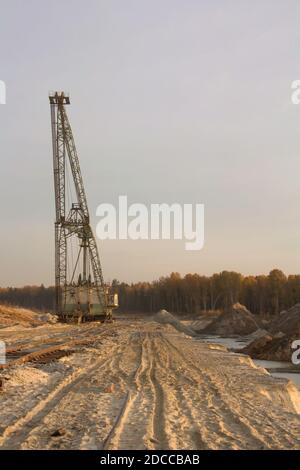 Un escavatore dragline in una cava di sabbia. Miniera di fosforite. Cingoli pneumatici su una sabbia. Foto Stock