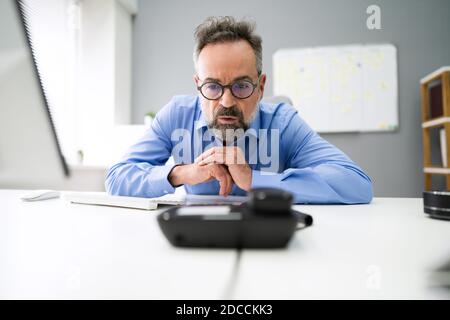 In attesa di telefono fisso o di chiamata telefonica alla scrivania dell'ufficio Foto Stock