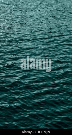 Mare acqua di fondo. Increspa sull'acqua blu trasparente in mare con riflesso del sole. Striscione verticale colorato in 2021 colori alla moda Foto Stock