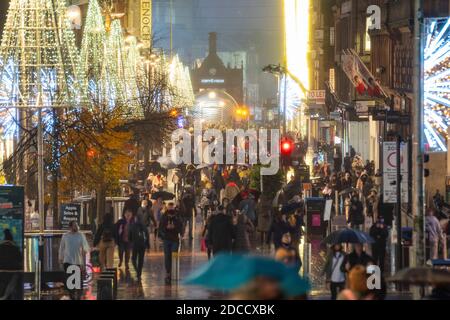 Glasgow, Scozia, Regno Unito. 20 novembre 2020. La sera, poco prima del blocco di livello 4 più severo, sarà imposto alle 18:00, gli acquirenti sono fuori per le strade di Glasgow facendo shopping di Natale all'ultimo minuto prima che i negozi chiuda per 3 settimane. La sera, i negozi e le aziende si chiudono. Nella foto; vista notturna lungo Buchanan Street ancora affollata di persone .Iain Masterton/Alamy Live News Foto Stock