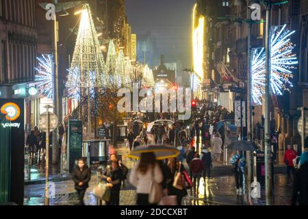 Glasgow, Scozia, Regno Unito. 20 novembre 2020. La sera, poco prima del blocco di livello 4 più severo, sarà imposto alle 18:00, gli acquirenti sono fuori per le strade di Glasgow facendo shopping di Natale all'ultimo minuto prima che i negozi chiuda per 3 settimane. La sera, i negozi e le aziende si chiudono. Nella foto; vista notturna lungo Buchanan Street ancora affollata di persone .Iain Masterton/Alamy Live News Foto Stock