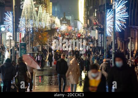 Glasgow, Scozia, Regno Unito. 20 novembre 2020. La sera, poco prima del blocco di livello 4 più severo, sarà imposto alle 18:00, gli acquirenti sono fuori per le strade di Glasgow facendo shopping di Natale all'ultimo minuto prima che i negozi chiuda per 3 settimane. La sera, i negozi e le aziende si chiudono. Nella foto; vista notturna lungo Buchanan Street ancora affollata di persone .Iain Masterton/Alamy Live News Foto Stock