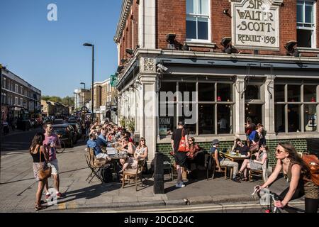 Cafe, ristorante sulla Broadway Street nella East London. La gente pranza ai tavoli sulla strada Foto Stock