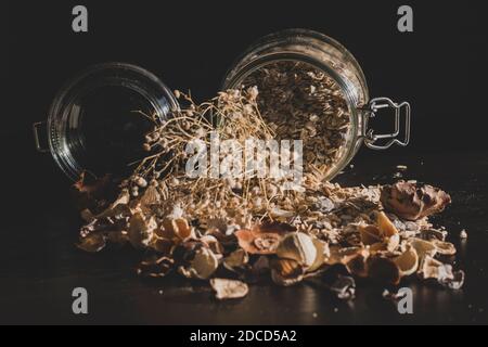 Colazione salutare servita al mattino con granaglie di mais, cereali interi e uvetta su sfondo scuro in stile vintage. Dieta sana nella mo Foto Stock