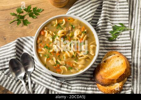 Zuppa di noodle di pollo fatta in casa con piselli e carote Foto Stock