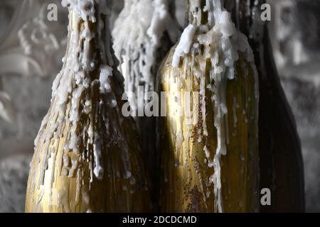 Messa a fuoco morbida su gocce di cera piena closeup su forme metalliche dipinte di colore dorato. Gocce di candela fuse. Struttura astratta con candela di paraffina in fusione Foto Stock