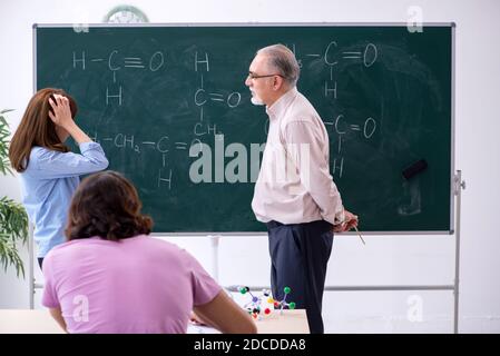 Insegnante anziano e due studenti in classe Foto Stock