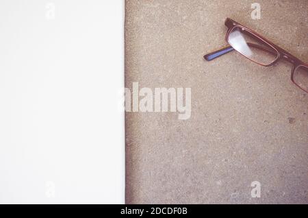 Una foto ad alto angolo di un paio di occhiali su una superficie ruvida Foto Stock