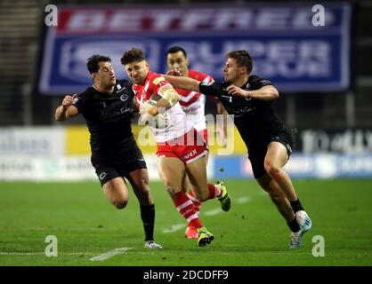 Tom Makinson di St Helens (al centro) affrontato da Benjamin Garcia di Catalans Dragons (a sinistra) e Tom Davies (a destra) durante la Betfred Super League, semifinale Play-off al Totally Wicked Stadium di St Helens. Foto Stock